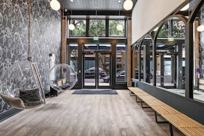 Enter through glass doors into a stylish space with a seating area and a unique hanging chair.