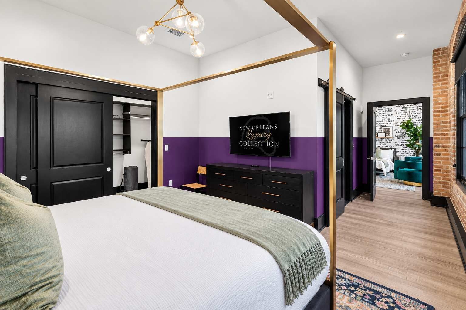 A modern hotel room with a bed, a dresser, a television, and a view of the outside.