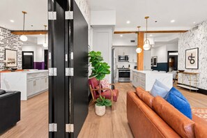 A modern kitchen with white cabinets, a microwave, and a stove. - 2 Living Room Suites Rooftop Perfect For Groups Hotel (New Orleans)