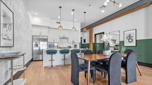 A modern kitchen with white cabinets, stainless steel appliances, and a central island.