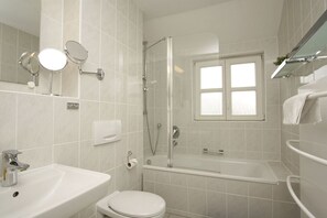 A modern bathroom with a bathtub, toilet, and sink. - Vacation apartment close to the beach with private terrace - Feriendorf Bakenberg FeWo C27 - (Dranske)