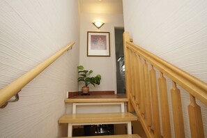 A wooden staircase with a potted plant on the landing.