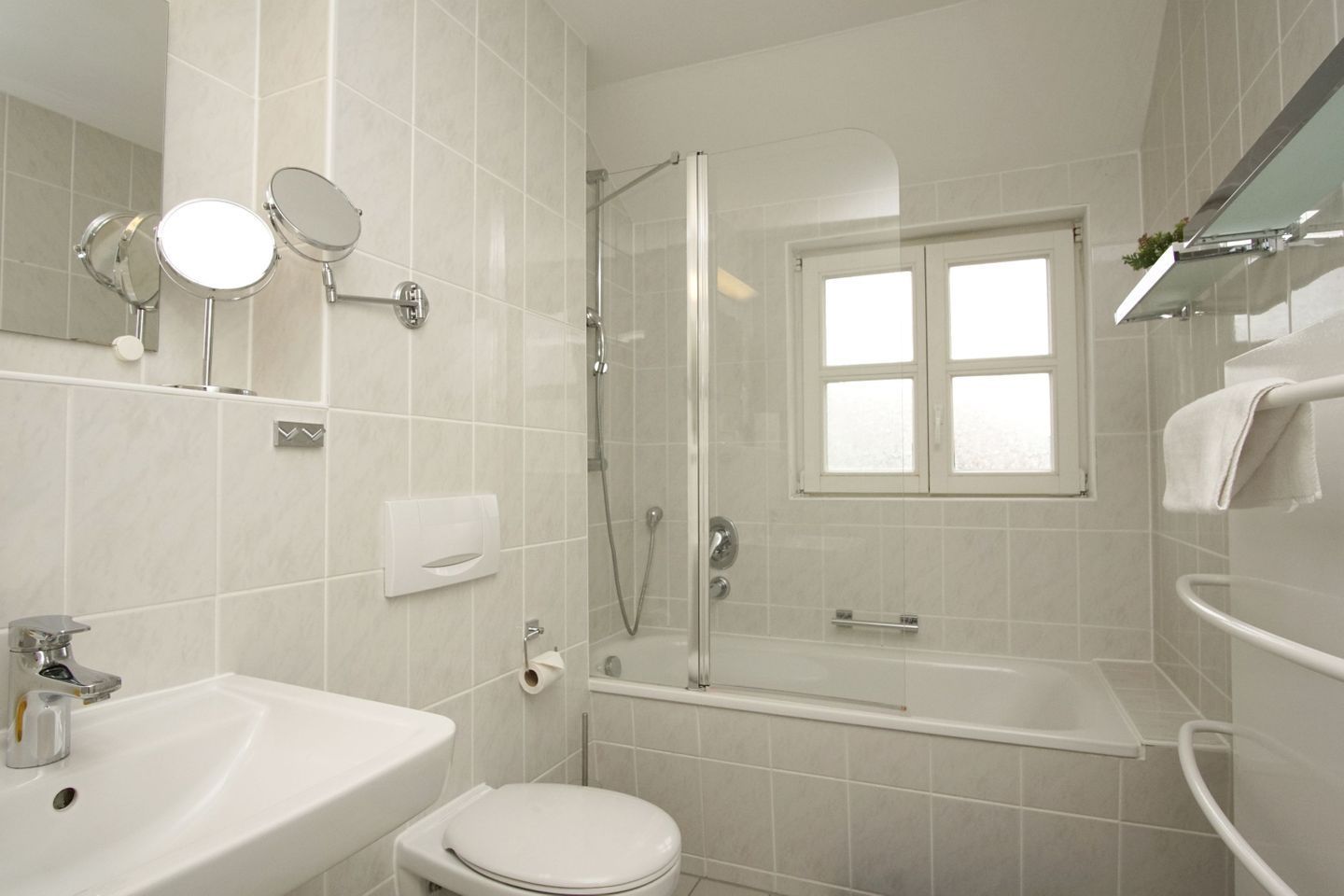 Une salle de bain moderne équipée d’une baignoire, de toilettes et d’un lavabo.