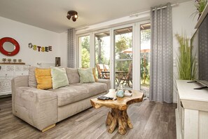 Una sala de estar con un sofá, una mesa de centro y vistas al exterior.