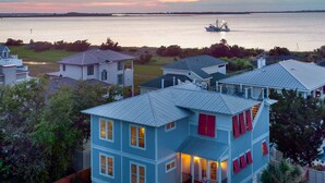 Une maison à plusieurs étages avec un balcon, un garage et une vue sur l  ’eau.