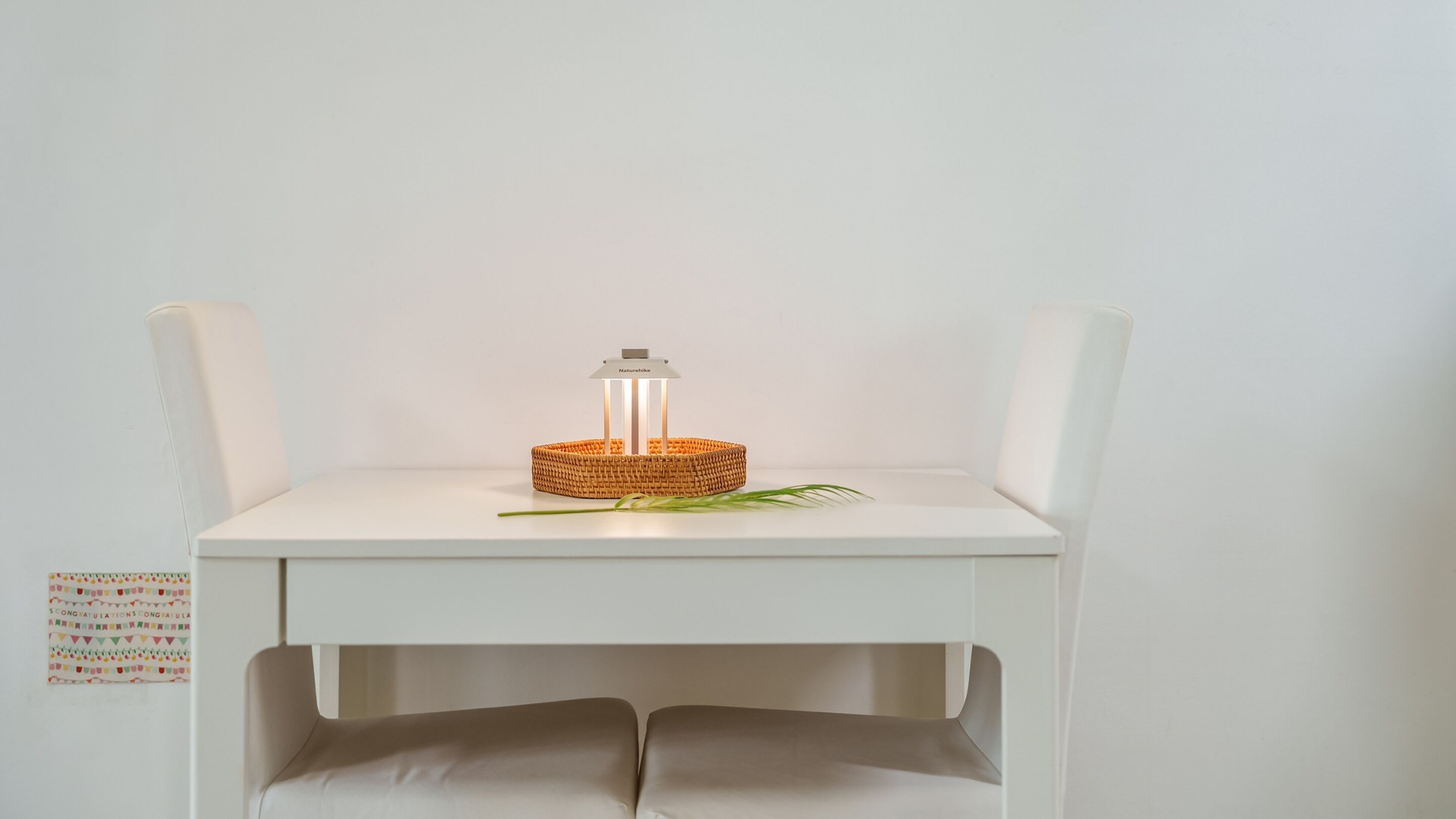 A white chair with a woven basket and a light on top.