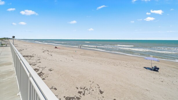 A beach with a clear sky, a sandy shore, and a few people and umbrellas. - 2 BR Beach Condo, Boutique Resort, 1st Fl Walkout, Steps to Pool & Beach Sleep 6 (Satellite Beach)