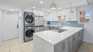 A modern kitchen with a central island, built-in appliances, and pendant lighting. - 2 BR Beach Condo, Boutique Resort, 1st Fl Walkout, Steps to Pool & Beach Sleep 6 (Satellite Beach)