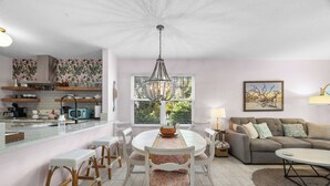 A modern kitchen with a dining area, a sofa, and a chandelier. - Updated! Beautiful Decor! Walk to Beach & Eats (St. Augustine)