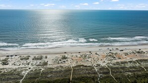 A beach with a clear sky, ocean waves, and sparse vegetation. - Updated! Beautiful Decor! Walk to Beach & Eats (St. Augustine)