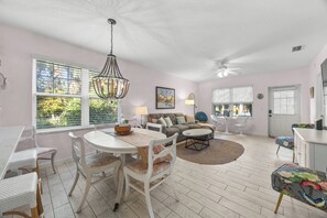 A room with a dining table, chairs, a sofa, a coffee table, and a ceiling fan. - Updated1 Beautiful Decor! Walk to Beach & Eats (St. Augustine)