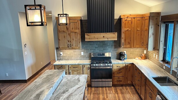 Une cuisine moderne avec des meubles en bois, un îlot central et une cuisinière intégrée.