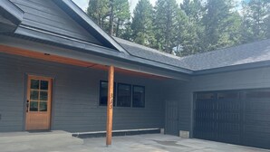 Une maison moderne avec un garage, une porte en bois et le numéro « 315 » peint sur le mur.