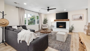 A modern living room with a grey sofa, round coffee table, and a fireplace. - Stunning Sequoia Hills Villa w/ pool, Game room, Hot tub, Firepit and EV charger (Three Rivers)