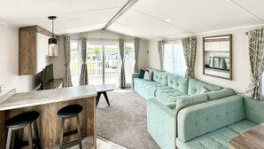 Un espacio de sala moderno con un sofá, una mesa de comedor y un televisor.