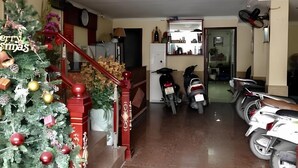 A living room with a staircase, a Christmas tree, and two scooters parked in the background. - Hoang Gia Hotel 150 Nghi Tam HN-BayLux (Hanoi)