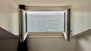 Una habitación con un ventanal que ofrece vistas al mar.