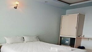 A bedroom with a large bed, a wardrobe, and a wall-mounted light fixture. - 31A Hotel CT by Bay Luxury (Can Tho)