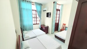 A room with two beds, a desk, a chair, and an air conditioning unit. - 31A Hotel CT by Bay Luxury (Can Tho)