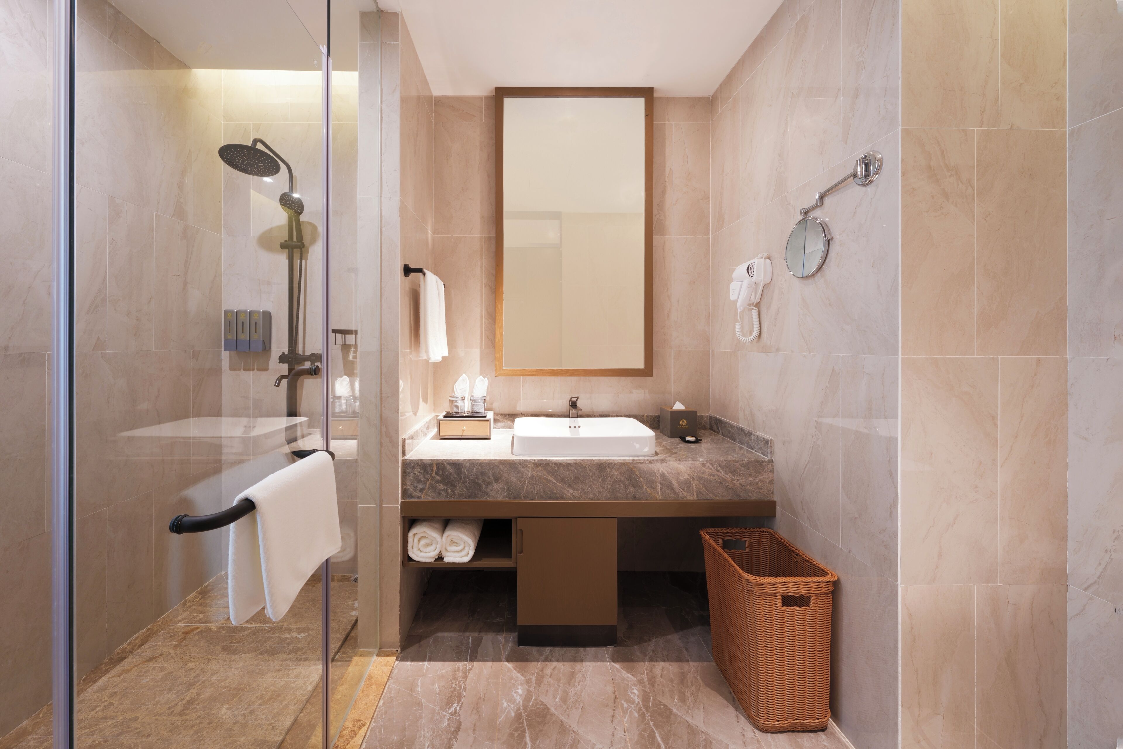 Ein modernes Badezimmer mit einer gläsernen Duschkabine, einem Waschbecken mit Spiegel und einem Korbwannenaufsatz.