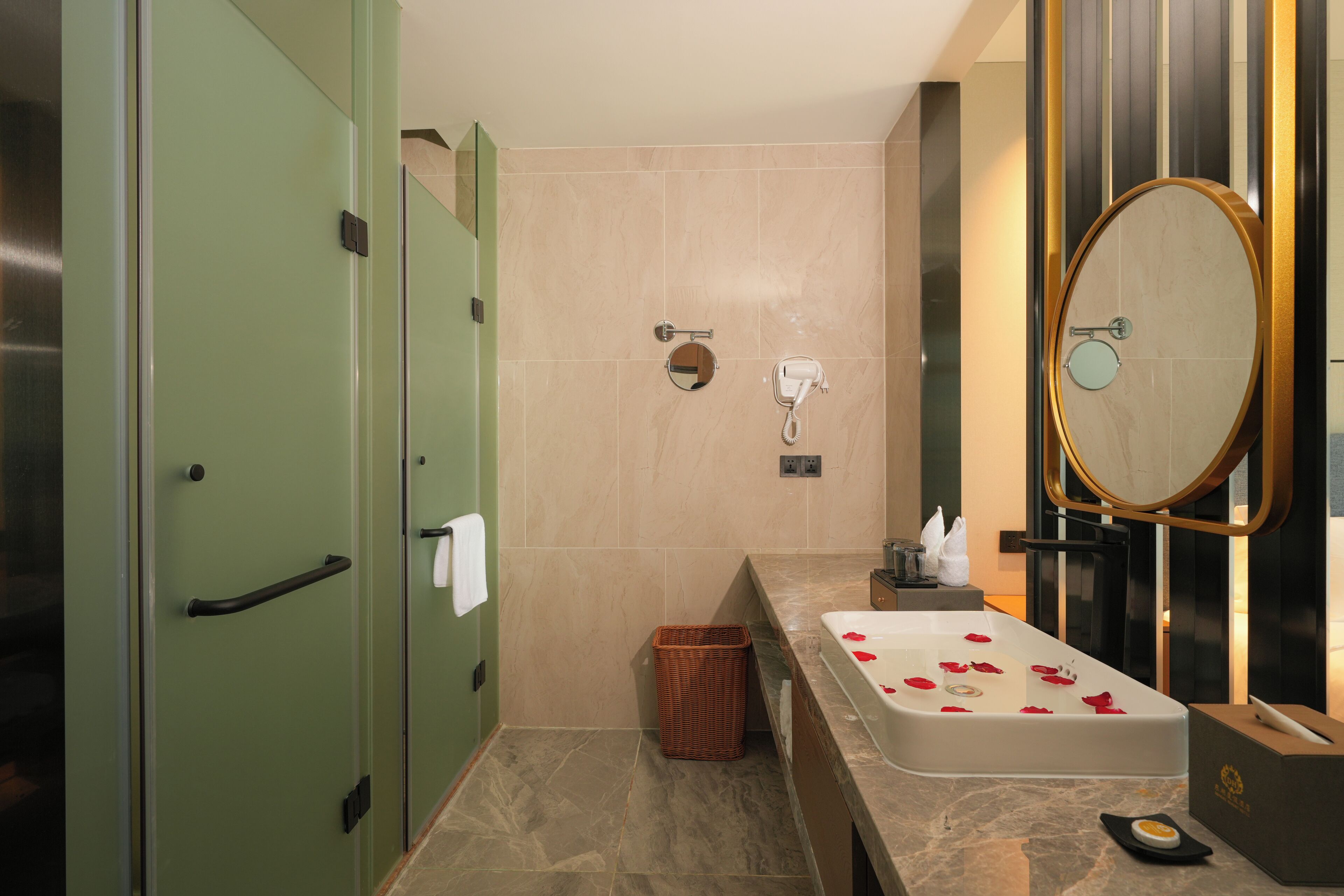 A modern bathroom with a marble sink, a large mirror, and a green door.