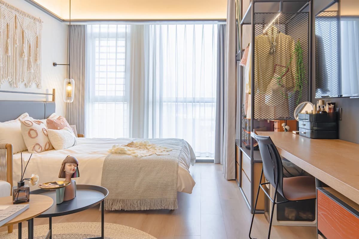Quarto de hotel moderno com uma cama grande, uma escrivaninha e um guarda-roupa.