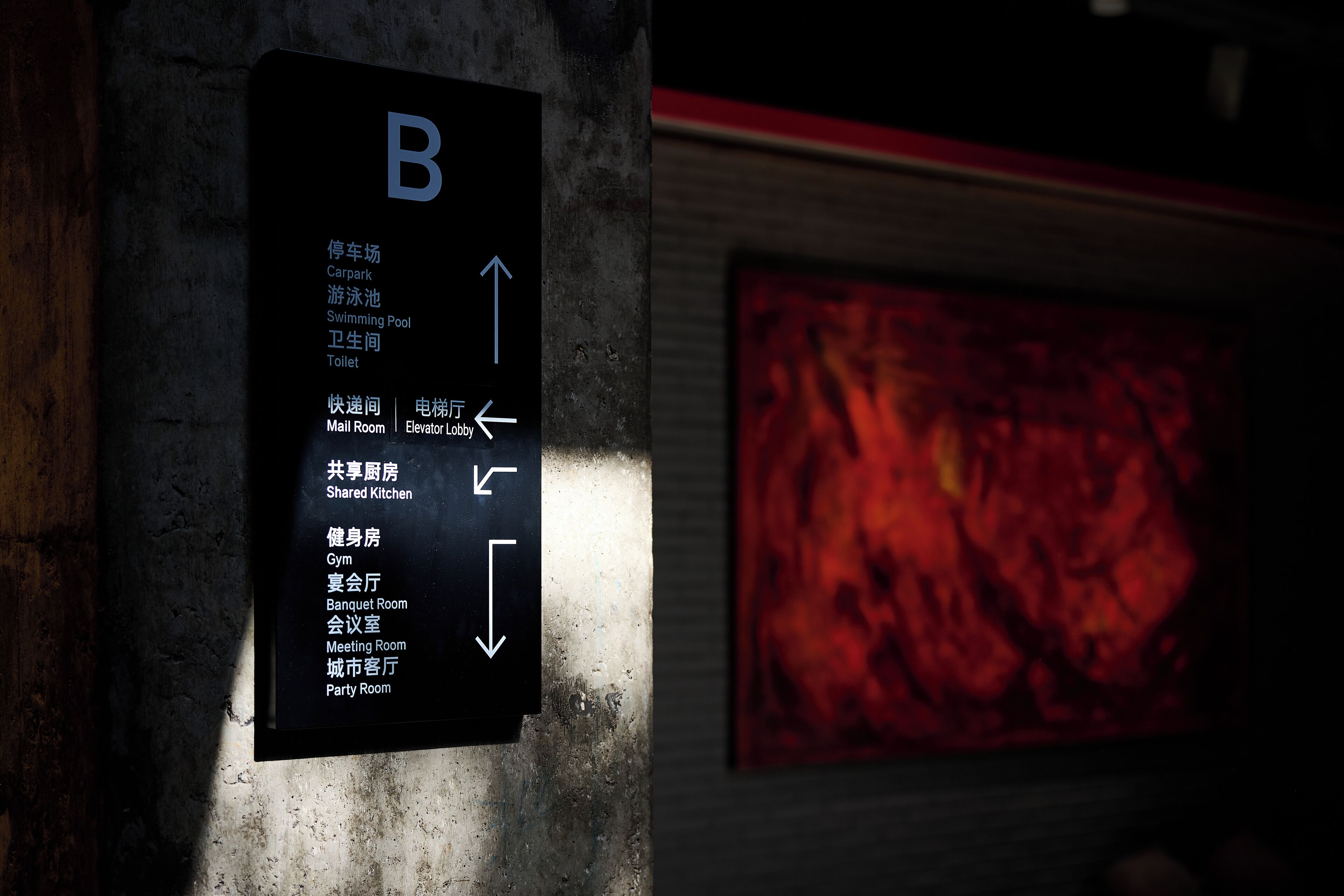 A directional sign with room names and arrows indicating their locations.