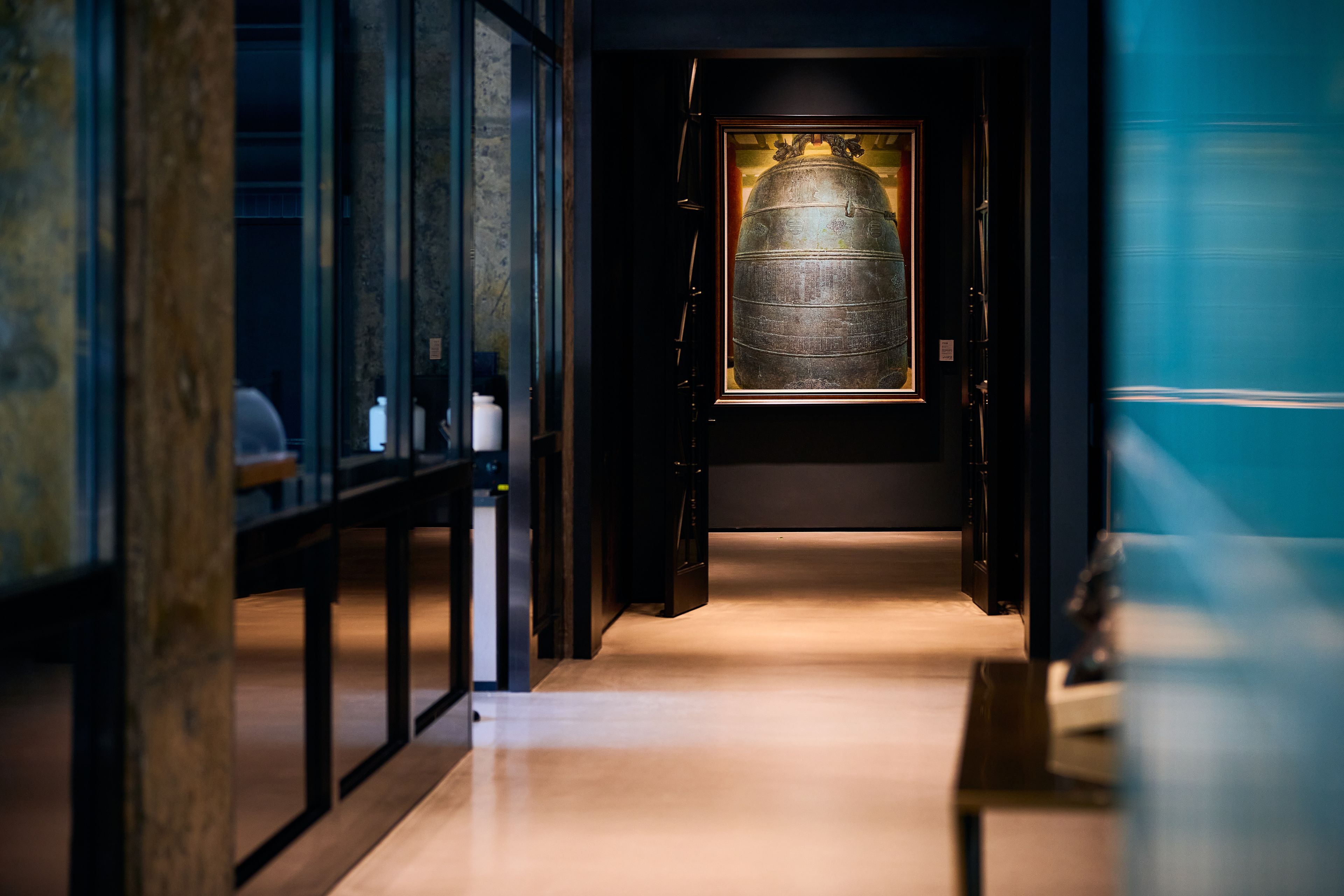 A corridor leading to a room with a large, illuminated artifact.