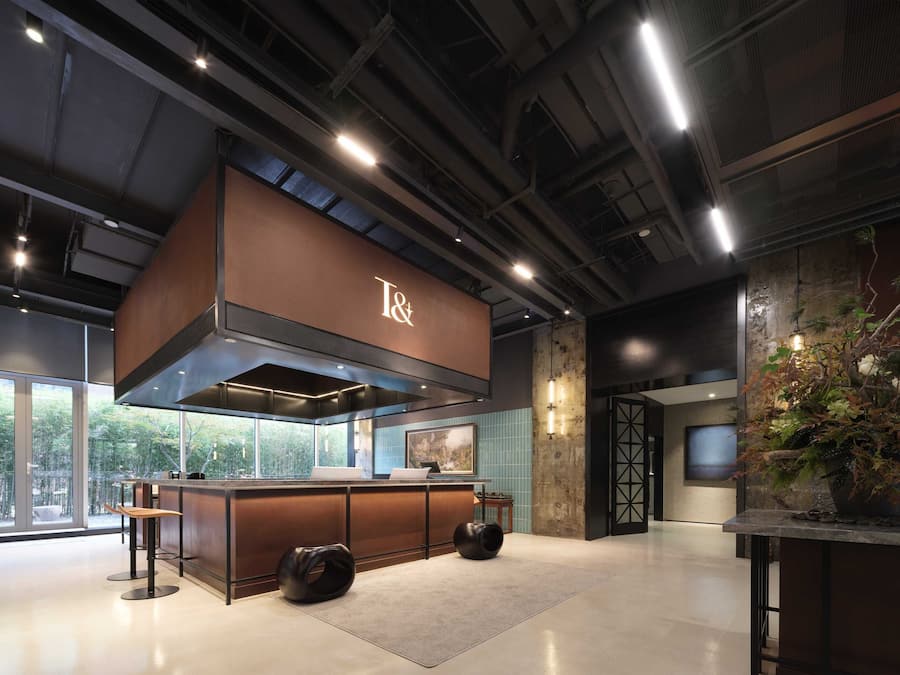 A modern kitchen with a T& coffee station, large windows, and a decorative plant.
