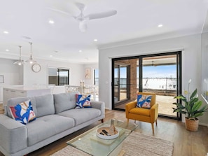 A modern living room with a grey sofa, a yellow armchair, and a glass coffee table.