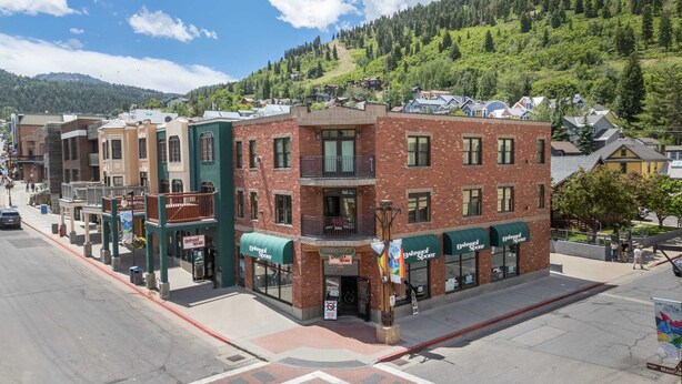 A multi-story building with a ground-floor retail space, a visible sign for 'Town Lift', and a mountainous backdrop. - 2BR Main St Condo, Walk to Ski Lift! (Park City)