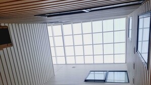 Une pièce dotée d’un plafond en pente et de plusieurs puits de lumière, ce qui permet à la lumière naturelle d’y pénétrer.