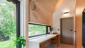 Eine moderne Küche mit großem Fenster, Holzschränken und einer integrierten Sitzbank.