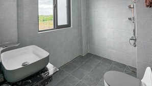A modern bathroom with a large window, a freestanding bathtub, a shower, and a toilet. - Nang Hotel - Phu Quy (Phu Quy)