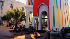 A multi-story building with a colorful facade, large windows, and a central arched entrance. - Nang Hotel - Phu Quy (Phu Quy)