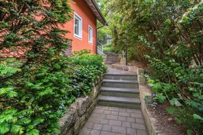 A red building with a stone staircase leading to a door.