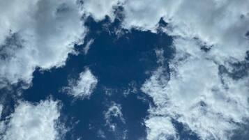 A view of the sky with clouds and the sun.