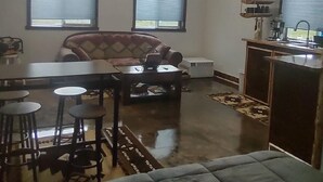 A cozy attic room with a dining area, a sofa, and a kitchenette. - Windy Ridge Cabin
Babb/St.Marys (Babb)