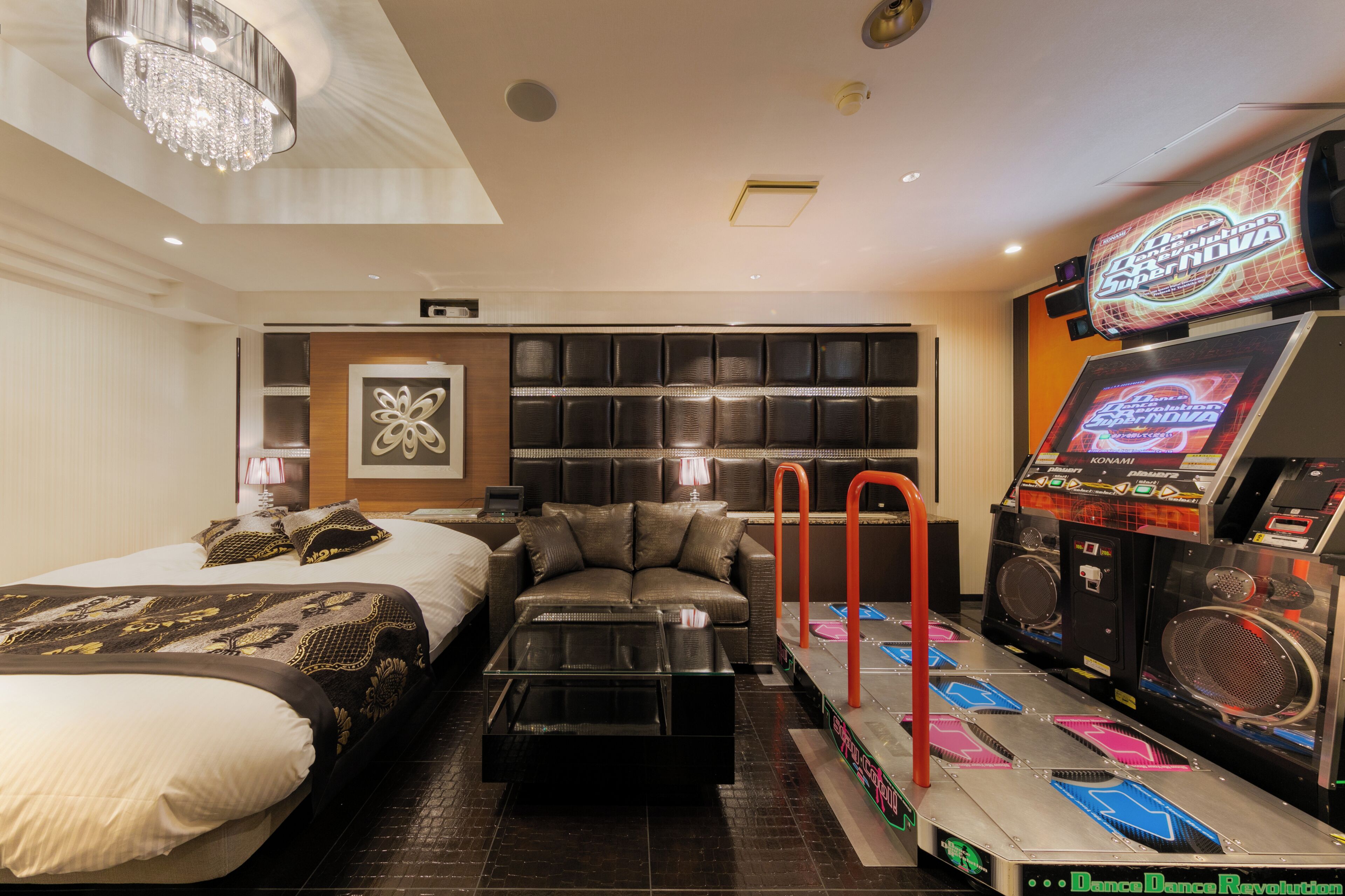 Habitación de hotel con cama, sofá, mesa de centro, televisor y zona de baile.