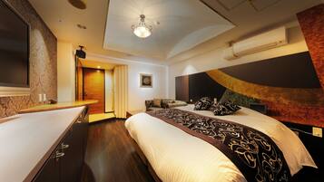 Una habitación de hotel moderna con una cama grande, un escritorio y una lámpara en el techo.