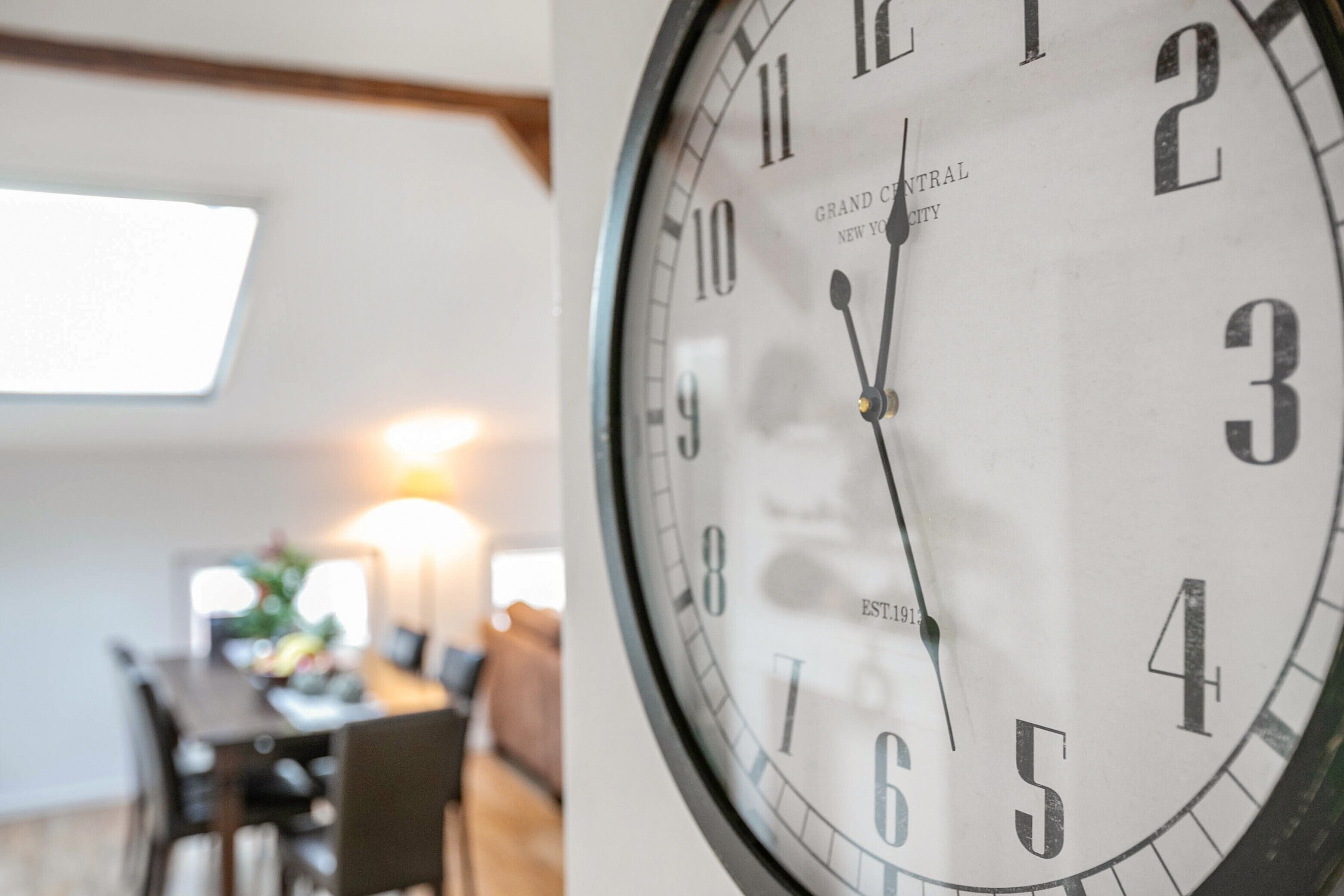 Eine Wanduhr mit weißem Zifferblatt und schwarzen Zahlen, die 12:30 Uhr anzeigt.