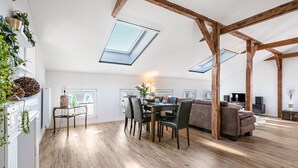 Un loft amplio con techos altos, tragaluces, un comedor y una zona de estar acogedora.