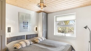 A bedroom with a bed, a window, a lamp, and a wall-mounted light fixture. - "Ljuba" - 1.3km from the sea by Interhome (Hjørring)