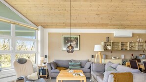 A modern living room with a sofa, armchair, coffee table, and a bookshelf. - "Ljuba" - 1.3km from the sea by Interhome (Hjørring)