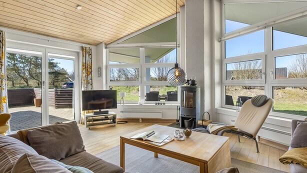 A spacious living room with a large window, a fireplace, and a television. - "Ljuba" - 1.3km from the sea by Interhome (Hjørring)