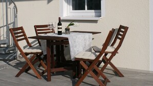 A patio with a table and chairs, a bottle of wine, and a window. - Apartment 'Ferienwohnung 2' with Private Terrace and Wi-Fi (Sulzbach an der Murr)