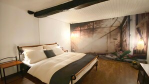 A bedroom with a wooden bed, a nightstand, a chair, and a wall mural. - Apartment 'Haus Auenland' with Shared Terrace, Garden, and Wi-Fi (Feldatal)
