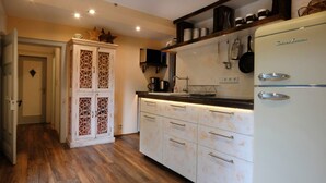 A kitchen with a vintage refrigerator, wooden cabinets, and a coffee maker. - Apartment 'Haus Auenland' with Shared Terrace, Garden, and Wi-Fi (Feldatal)