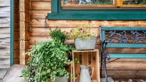A wooden cabin with a window, a bench, and potted plants. - Holiday Home 'Häuschen Grau' with Private Garden and Wi-Fi (Scheibenberg)