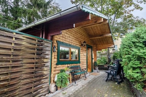 Eine Holzhütte mit Veranda, einer Bank und einem Tisch mit Stühlen.
